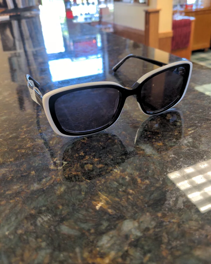 Black and white cat eye sunglasses standing on the polished granite counter.